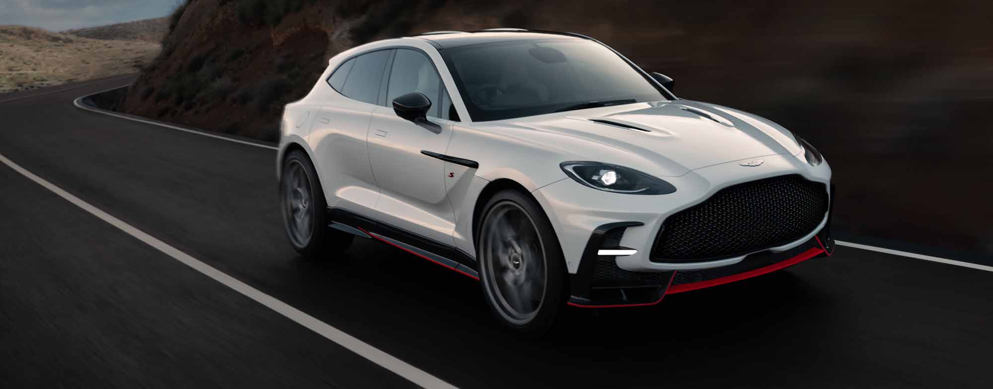 Aston Martin DBX S driving around mountain
